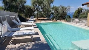 A swimming pool with sun loungers and a view of the sea. - Villa Malù - APT Amalia - Pool and lake view (Torri del Benaco VR, Italia)