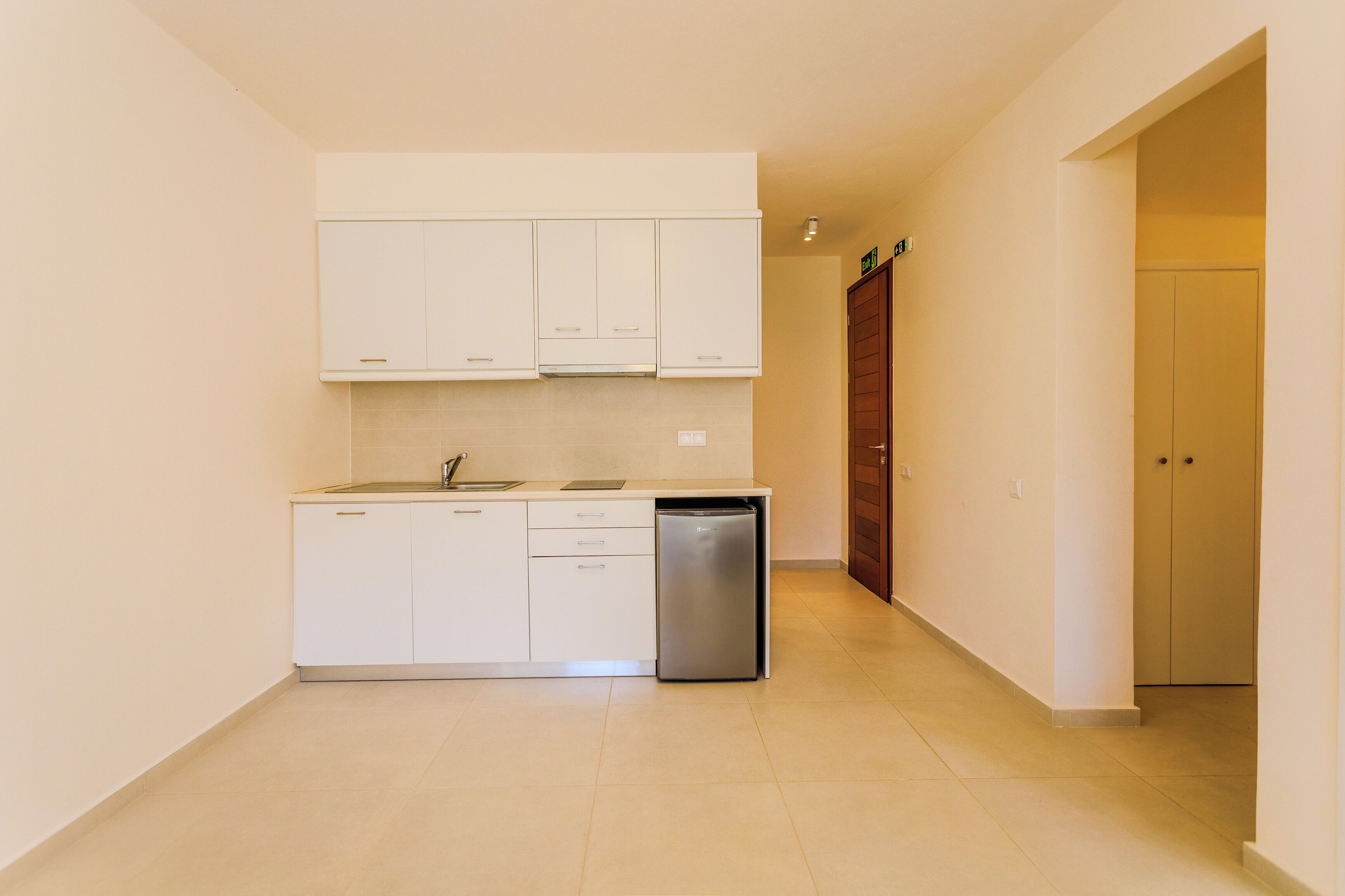 A kitchen with white cabinets, a sink, and a dishwasher.