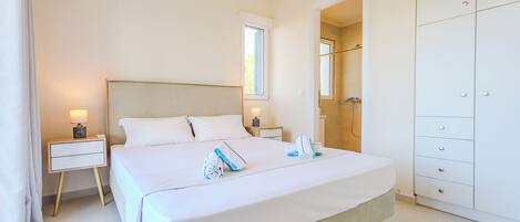 A hotel room with a bed, bedside table, lamp, and a wardrobe.