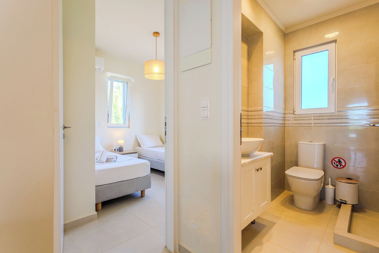Une chambre d’hôtel avec un lit, une table de chevet, une lampe et une vue sur la salle de bain.