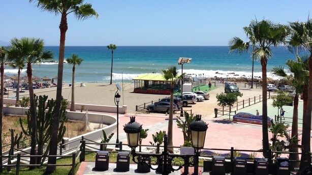 A beachside promenade with palm trees, a boardwalk, and a view of the ocean. - Monte Duquesa, ground floor, 2 bed close to Port and Beach (Manilva)