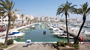 A marina with boats docked, surrounded by palm trees and white buildings. - Monte Duquesa, ground floor, 2 bed close to Port and Beach (Manilva)
