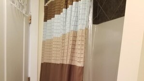 Kylpyhuone, jossa on geometrisesti kuvioitu suihkuverho.