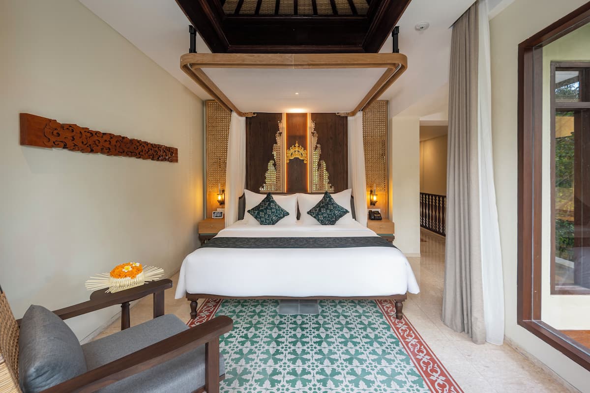 A bedroom with a large bed, a wooden headboard, and a patterned rug.