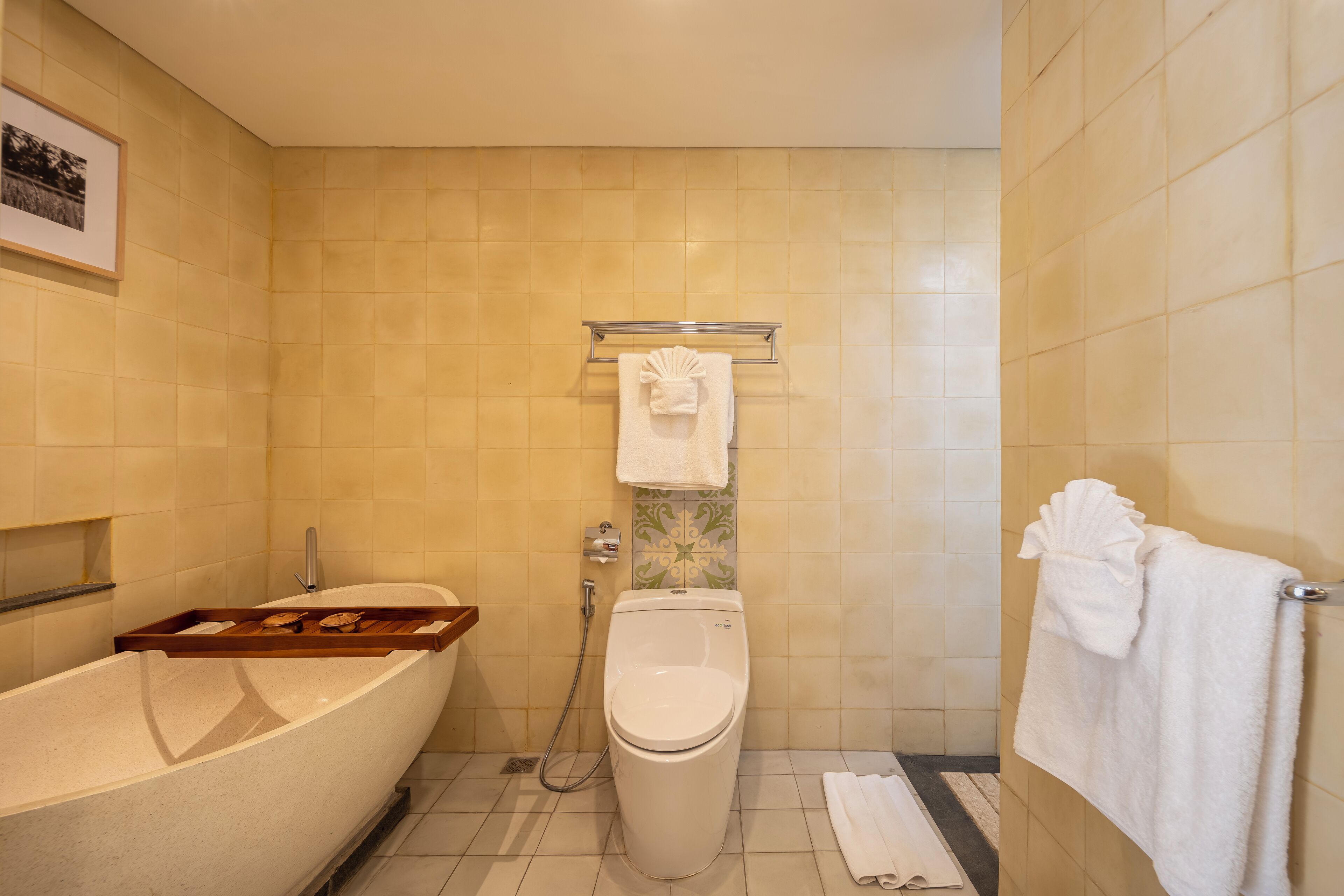A bathroom with a bathtub, toilet, and a towel rack.