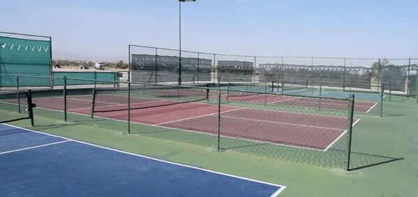 A tennis court with multiple courts, a net, and a green fence. - Charming 3-Bedroom Casa Chaparral (San Felípe)