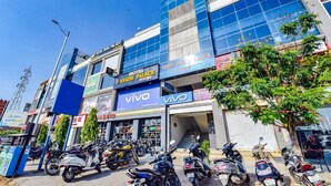 A hotel with multiple floors, including a visible restaurant and a Vivo store. - Hotel Avadh Palace (Ahmedabad)