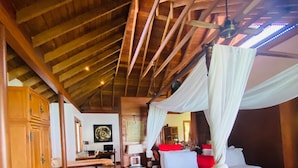 A wooden-floored room with a bed, a desk, and a chair. - Villa Hutan Datai (Langkawi)
