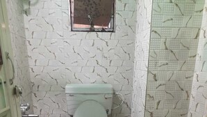 Casa de banho pequena com sanita, janela e lavatório.