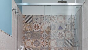 A bathroom with a shower, toilet, and sink.