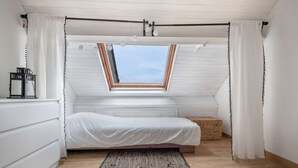 A bedroom with a skylight, a bed, a bedside table, a lamp, and a rug. - House for 5 at a few steps from the beach (Arzon)