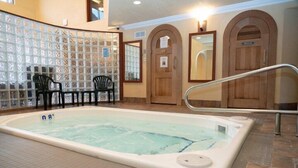 An indoor swimming pool with a tiled floor, wooden doors, and a glass partition with chairs. - Comfy Room Along Banff Ave! Air-Conditioning (Banff)