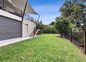 Stroll through the beautifully landscaped grounds, surrounded by trees and shrubs, and enjoy the covered balcony with a staircase leading up to it.