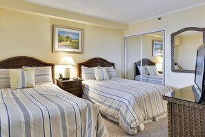 A hotel room with two beds, a nightstand with a lamp, a large mirror, and a framed picture on the wall. - XPLORIE ACTIVITIES & LINENS INCLUDED*! Direct Oceanfront 3BR/2BA condo in The Plaza. Indoor and Outdoor Pools and Tiki Bar. (Ocean City)