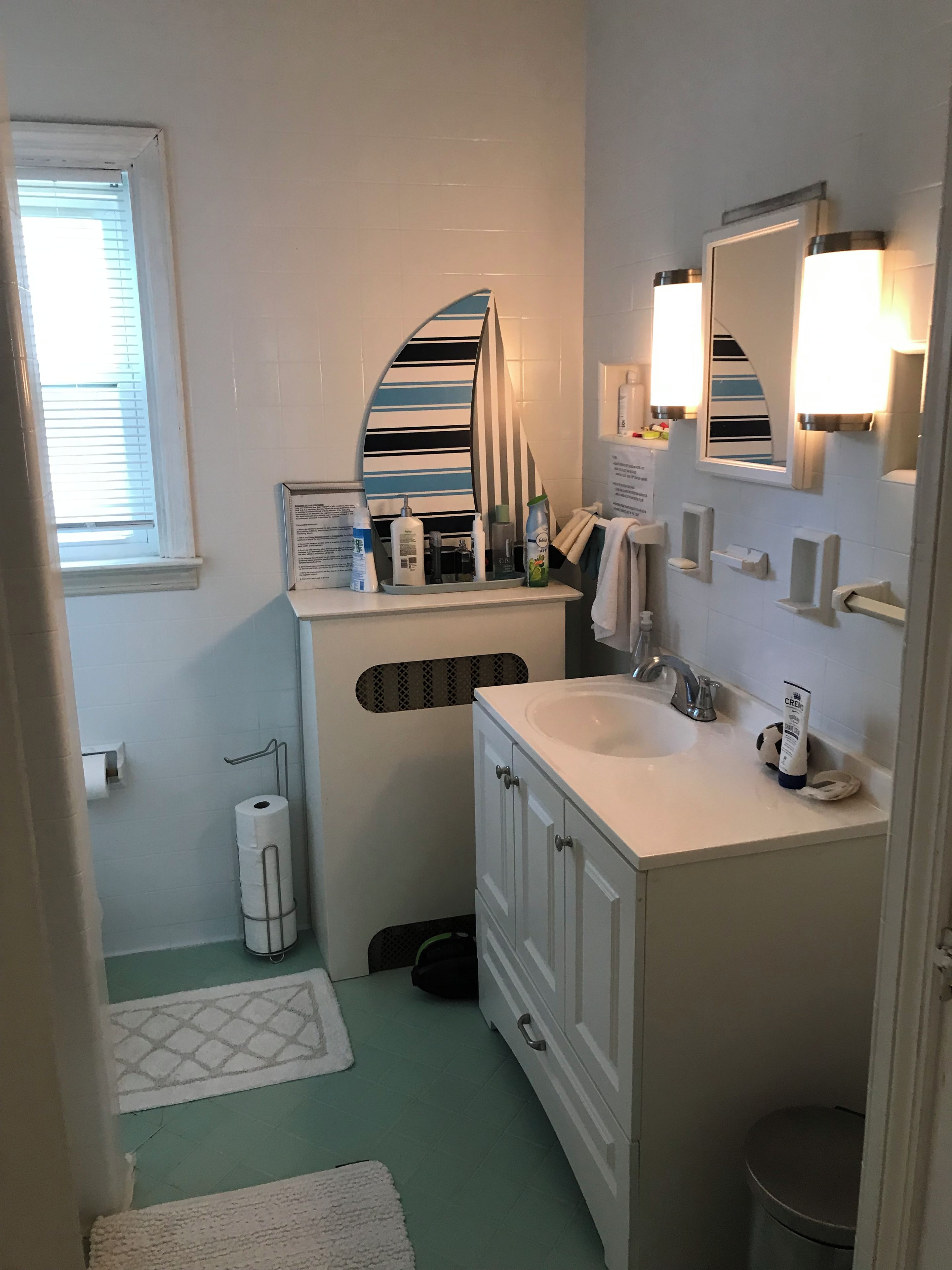 A bathroom with a white sink, a mirror, and toiletries on the counter.