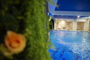 A swimming pool with a water feature, lounge chairs, and a modern architectural design. - Doanesia Premium Hotel & Spa (Tirana)