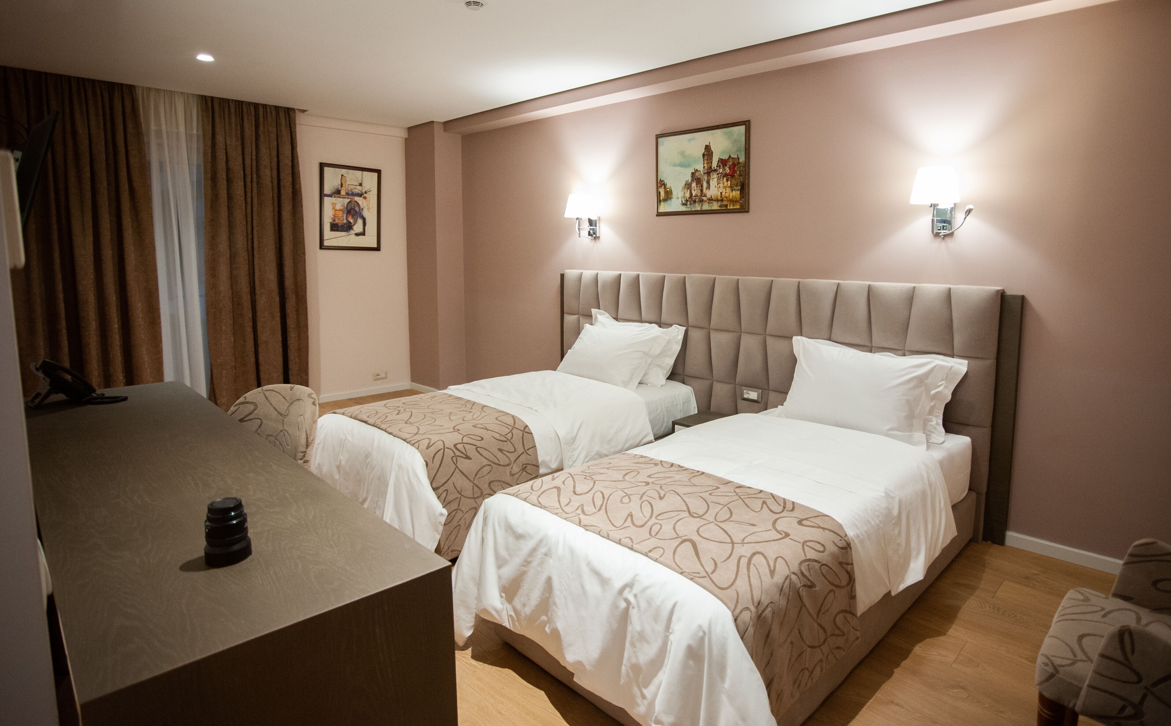 Une chambre d’hôtel avec deux lits, un bureau et une chaise.