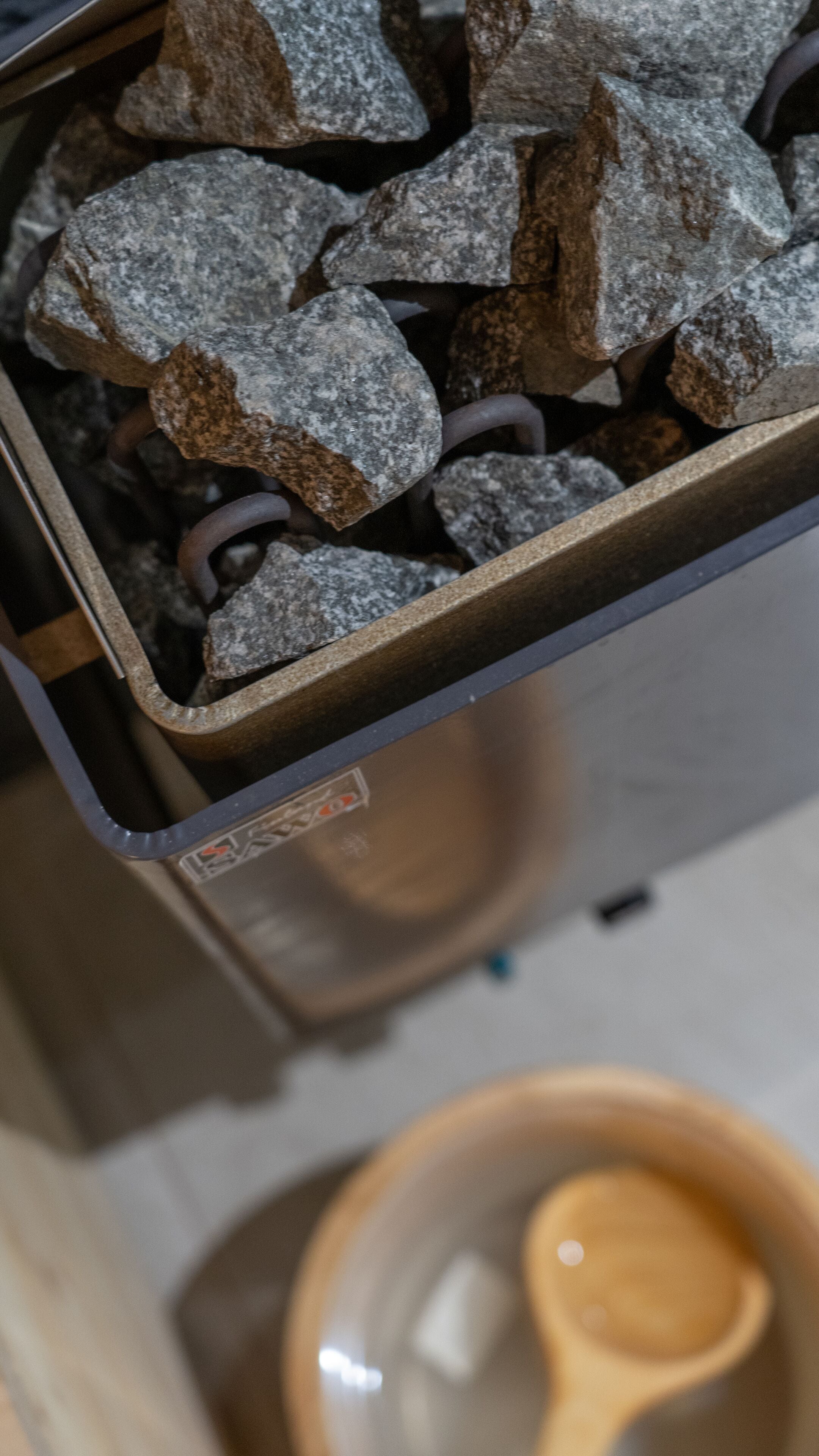 A trash bin filled with rocks and a metal container.