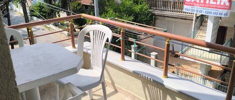 Ein Balkon mit Tisch und Stühlen, einem Geländer und Blick auf die Umgebung.