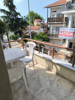 A balcony with a table and chairs, a railing, and a view of the neighborhood. - Avşar Apart Motel (Marmara)