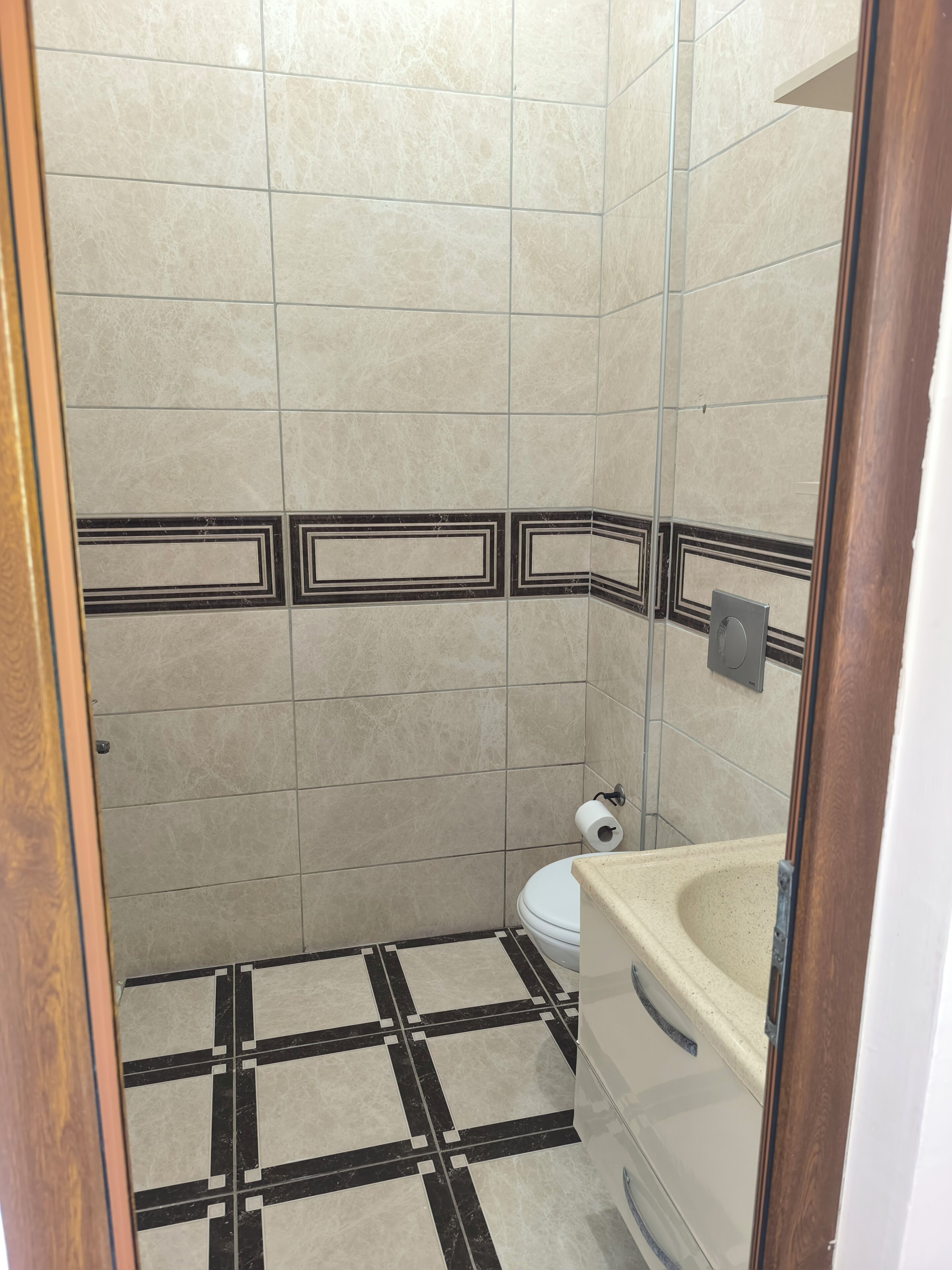 Un baño pequeño con inodoro, lavamanos y zona de ducha.