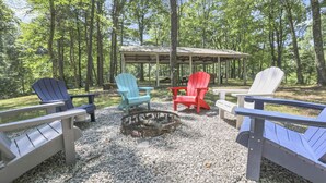 A covered outdoor seating area with Adirondack chairs and a fire pit. - Gentle Breeze: The Maple: Romantic Secluded Getaway (Lancaster)