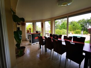 Ein geräumiger Essbereich mit Blick auf einen Pool und üppiges Grün.