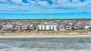 A coastal residential area with beachfront properties, a sandy beach, and a clear blue sky. - Direct Oceanfront, Cherry Grove, Elevator, 2 Bedroom Condo (North Myrtle Beach)
