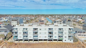 A multi-story residential building with balconies, a marina, and a clear view of the ocean. - Direct Oceanfront, Cherry Grove, Elevator, 2 Bedroom Condo (North Myrtle Beach)
