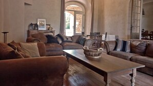 Una sala de estar acogedora con una mesa de madera, sofás de cuero y una pared de piedra.