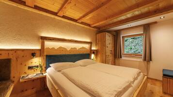 Quarto de cabana de madeira com cama, mesa de cabeceira, janela com cortinas e teto de madeira.
