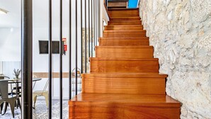 A wooden staircase with a stone wall on one side and a metal railing on the other. - Holiday Home 'Casa Azul' with Mountain View, Shared Pool and Wi-Fi (Moledo)