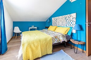 A bedroom with a bed, a desk, a chair, and a decorative headboard. - Holiday Home 'Casa Azul' with Mountain View, Shared Pool and Wi-Fi (Moledo)
