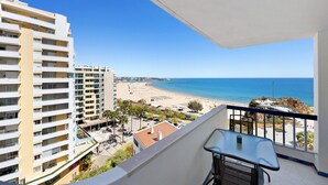 Een balkon met uitzicht op strand en zee.