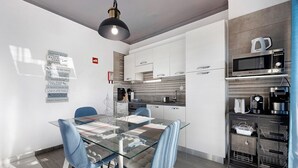 A modern kitchen with white cabinets, a microwave, and a coffee maker. - Apartment "Refúgio Praia da Rocha" with Sea View, Balcony & Wi-Fi (Portimão)