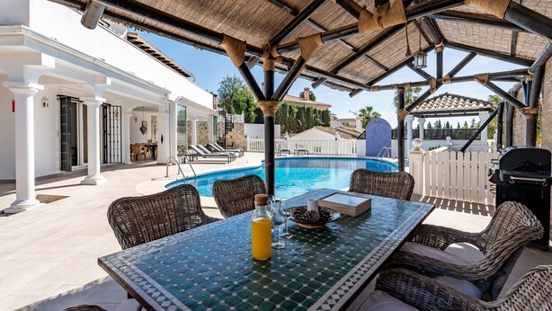 A poolside area with a table, chairs, and a grill. - Holiday Home 'Beachfront Luxury Villa La Cala' with Private Pool, Wi-Fi and Air Conditioning (Las Lagunas de Mijas)