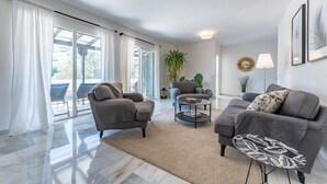 A modern living room with two sofas, a coffee table, and a large window with curtains. - Holiday Home 'Beachfront Luxury Villa La Cala' with Private Pool, Wi-Fi and Air Conditioning (Las Lagunas de Mijas)