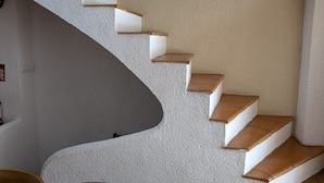 Eine Wendeltreppe mit weißen Wänden und Holzstufen.
