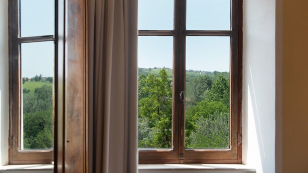 A window with a view of a green landscape. - Apartment 'La Rocca di Efisio - Grignolino' with Balcony, Wi-Fi and Air Conditioning (Costigliole d'Asti)