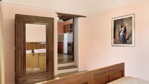 Una camera da letto con una struttura letto in legno, un grande specchio e un quadro appeso al muro.