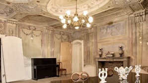 A room with a chandelier, a fireplace, a television, and ornate furniture. - Apartment 'La Rocca di Efisio - Barbera with Private Terrace, Wi-Fi and Air Conditioning (Costigliole d'Asti)