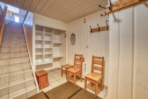 Una escalera conduce a una habitación con sillas de madera, una mesita y un radiador.