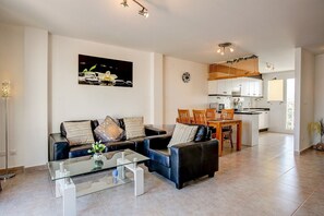A modern living room with a sofa, coffee table, and a painting on the wall.