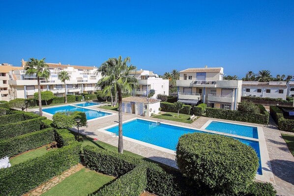 A resort with multiple swimming pools, lush greenery, and modern buildings.