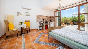 A bedroom with a bed, a desk, a chair, a table, and a view of the outdoors. - Studio Sur – Adults Only in Mallorca with Shared Pool (Manacor)