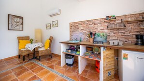 A compact kitchen with a stone wall backsplash, a small sink, and a refrigerator. - Studio Sur – Adults Only in Mallorca with Shared Pool (Manacor)