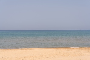 Una playa con agua cristalina y una orilla arenosa.