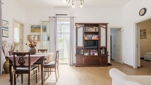 Een eetgedeelte met een tafel, stoelen en een boekenkast.