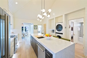 A modern kitchen with a central island, stainless steel appliances, and a large window. - Brand-New Luxury Renovation in Seaside; 2 King Suites; Designer Kitchen (Santa Rosa Beach)