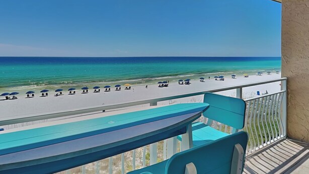 Ein Balkon mit Blick auf Strand und Meer.